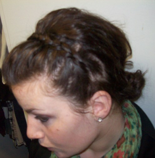 It starts as a side braid, somewhere behind or before your ear, french braiding (or corn-rowing [pulling under, instead of over, like in a french braid] like I have done in the picture) it up until you get to the point right before your eyebrow arch starts. At this point, just braid the strand normally for about two and a half inches or so…